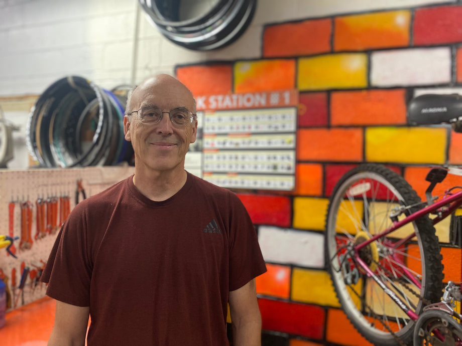 Volunteer Norm, standing in front of an orange workbench.