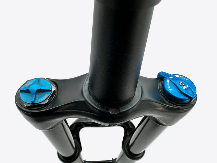 Close-up of a bicycle fork with blue adjustment knobs on a light gray background
