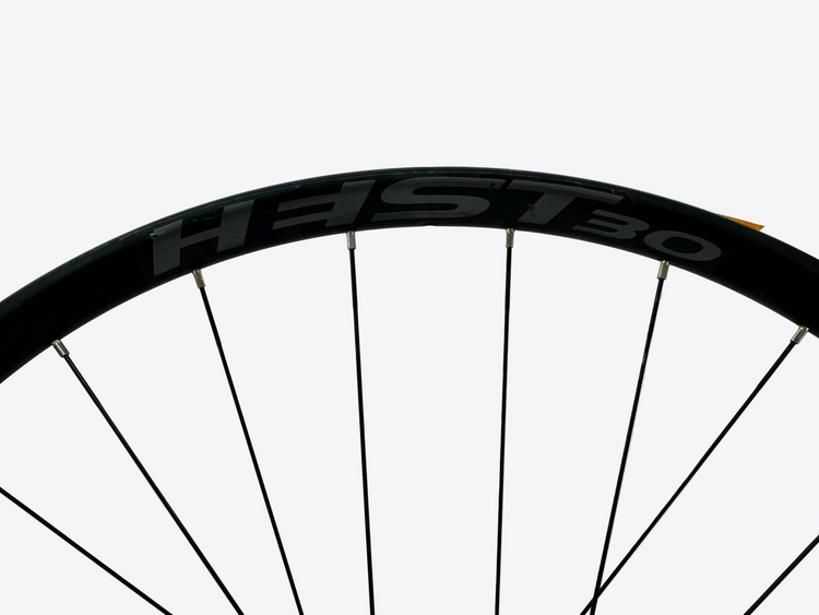 Close-up of a bicycle wheel with HEST 30 branding on a white background