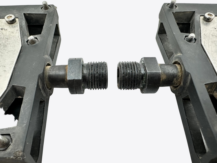 Two metal bolts between two black metal frames on a white background