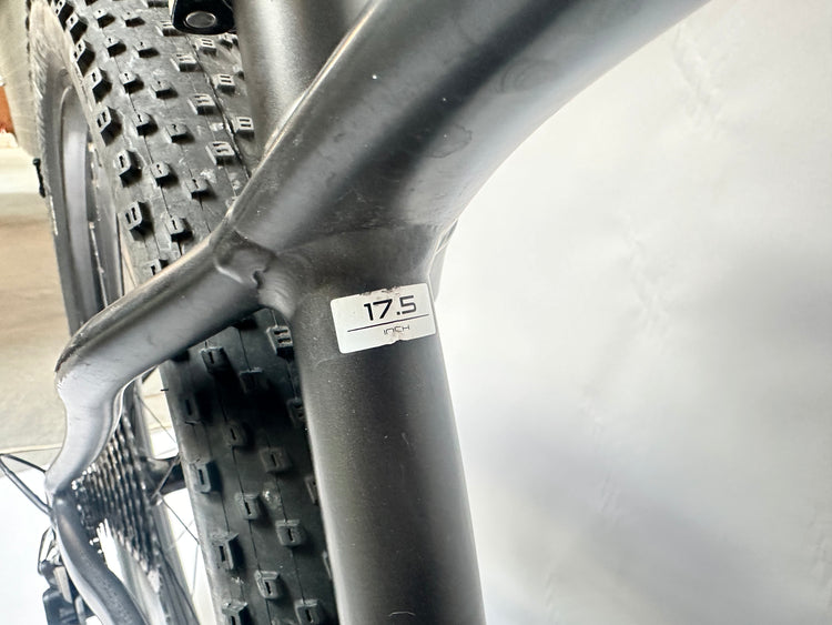 Close-up of a bicycle tire with tread pattern and size label on a blurred background