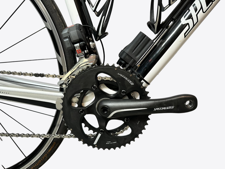 Close-up of a bicycle's chain mechanism with 'Specialized' branding on a white background