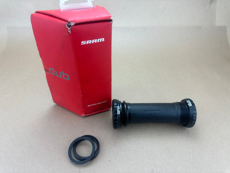 Black bicycle bottom bracket with SRAM packaging on a light gray background