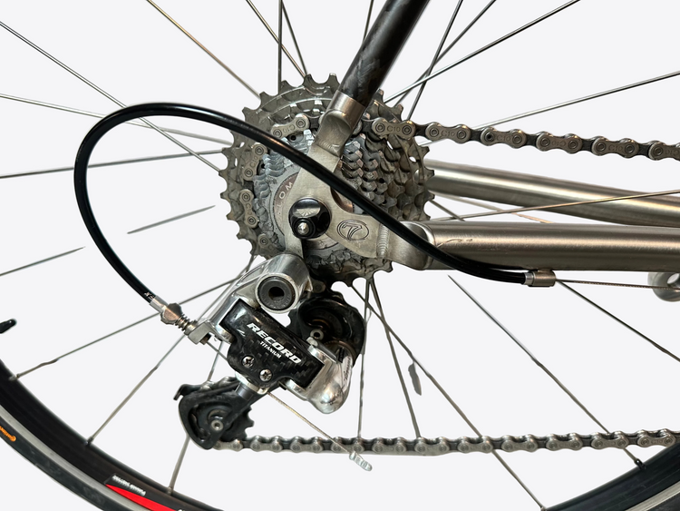 Close-up of a bicycle's gear system on a tiled floor.