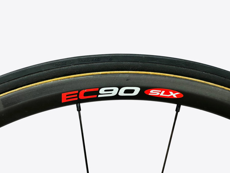 Close-up of a bicycle wheel with 'EC90 SLX' branding on a light gray background