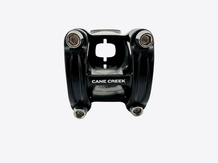 A black Cane Creek bicycle stem with silver bolts, photographed on a light gray background.