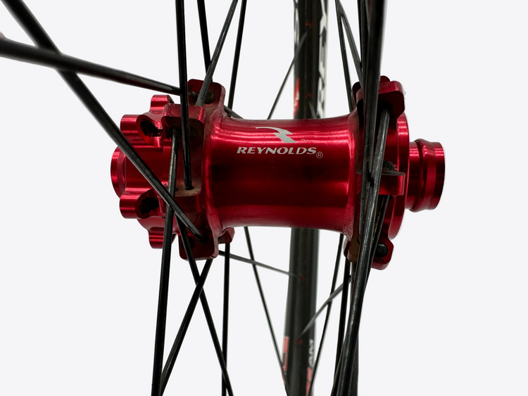 Close-up of a red Reynolds bicycle hub on a gray background