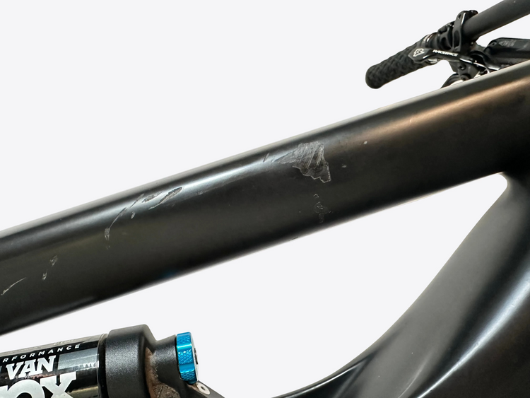 Close-up of a bicycle frame with visible wear and brand logos.