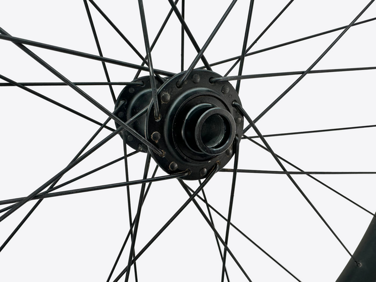 Close-up of a bicycle wheel hub with spokes against a light background