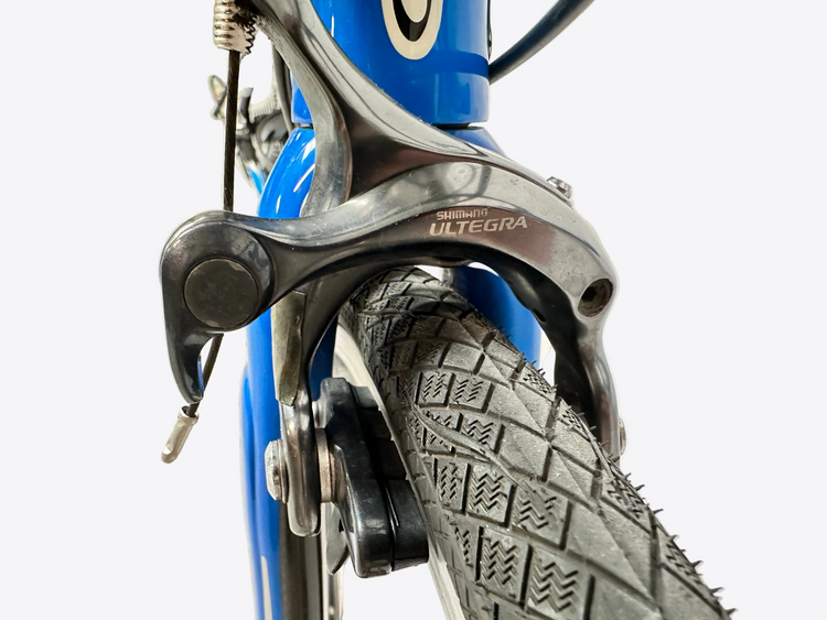 Close-up of a bicycle brake mechanism with 'Ultegra' branding on a blurred background