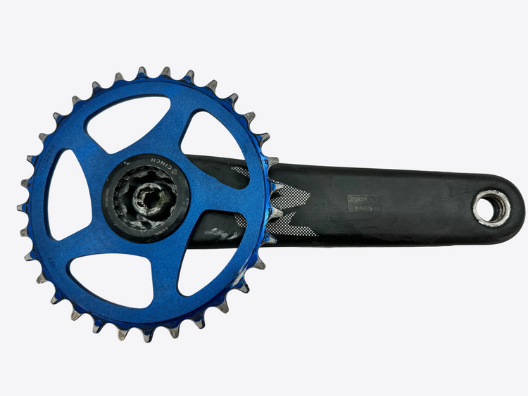 A bicycle crankset component featuring a bright blue chainring with black teeth, a black crank arm, and a black central hub, photographed on a plain off-white background.