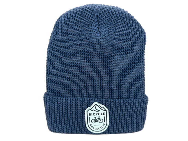 Blue knit beanie with a logo on a light background