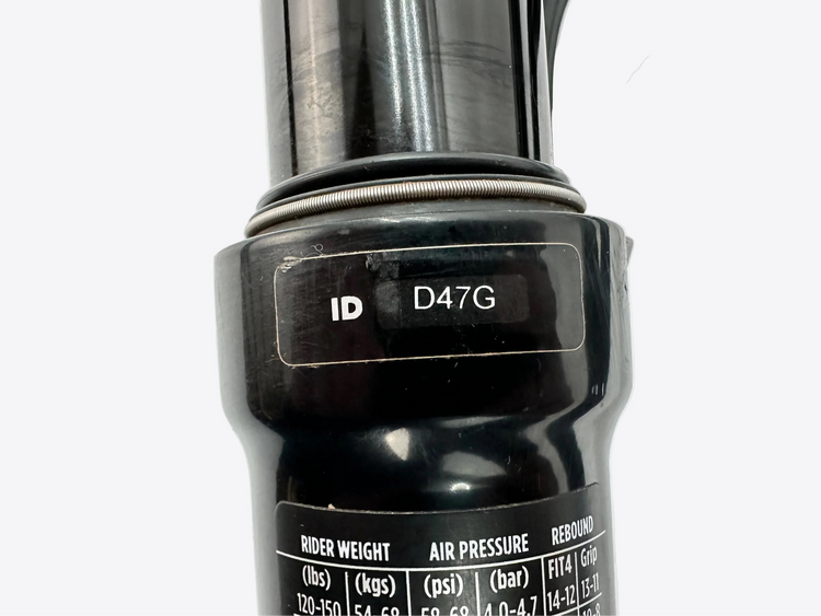 Close-up of a bicycle suspension fork with branding and specifications on a white background