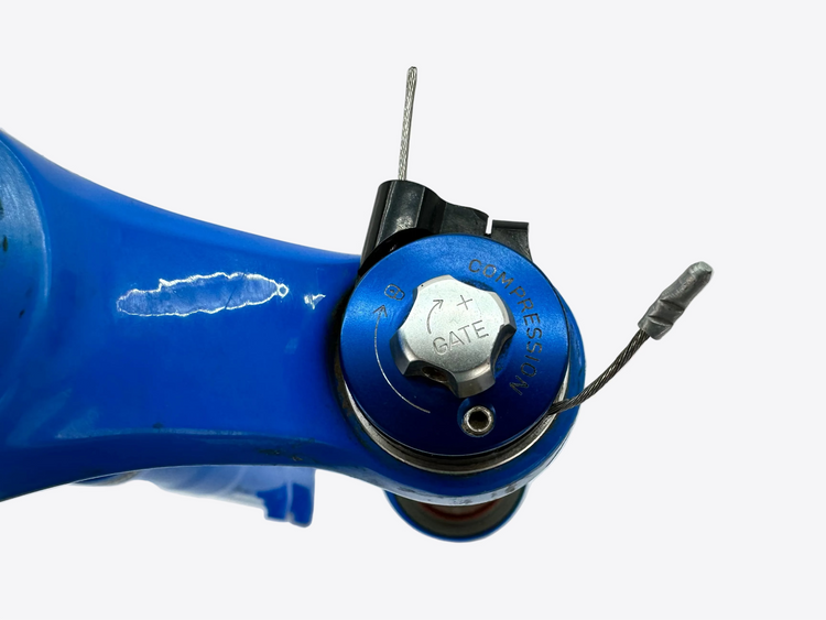Close-up of a blue bicycle component with 'Cannondale' branding on a gray background