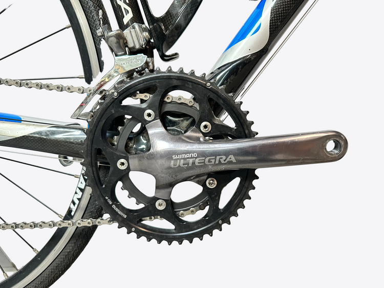 Close-up of a bicycle crankset with Shimano Deore brand name on a blurred background