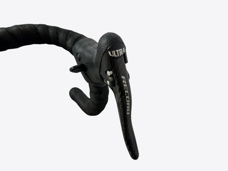 Close-up of bicycle brake levers with 'Record' branding on a blurred background