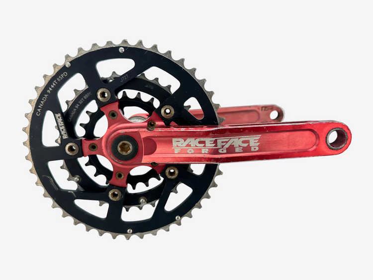 Bicycle crankset with red arm and black sprockets on a white background