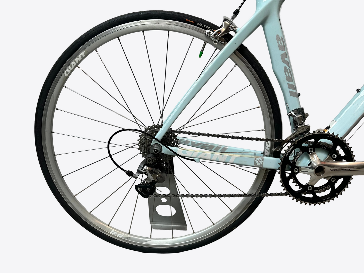Close-up of a bicycle wheel with a white wall background