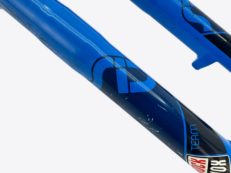Close-up of a blue and black bicycle frame with 'FOX' branding on a white background
