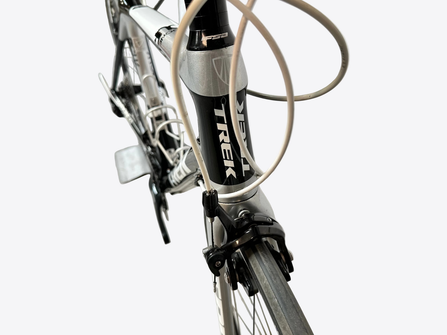 Close-up of a Trek bicycle with a white frame and black components on a concrete floor.