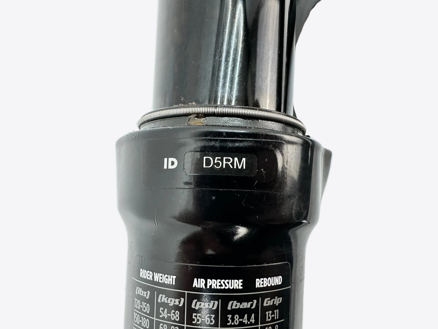 Close-up of a black suspension fork with 'D5RM' branding on a white background