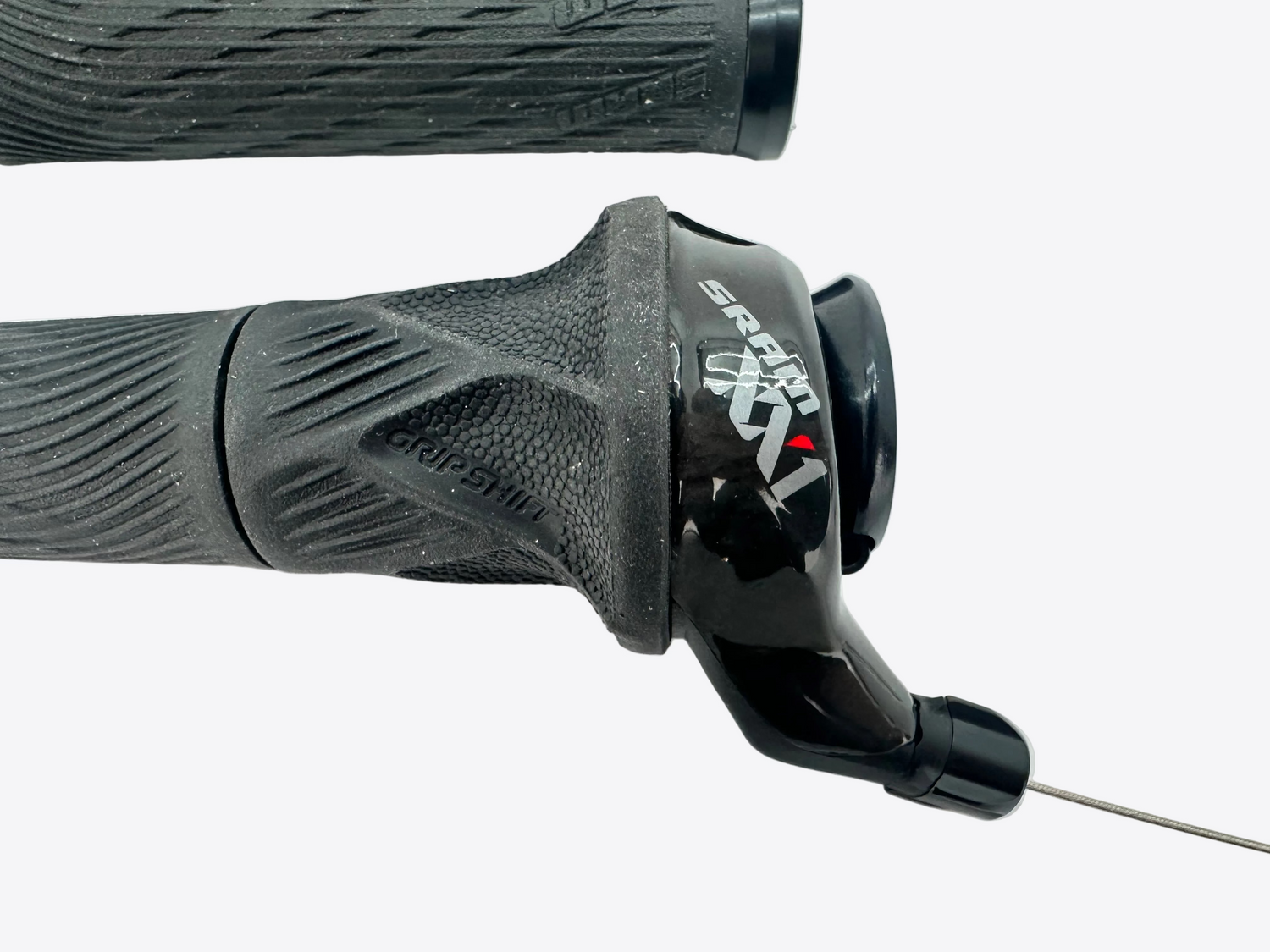 Close-up of black bicycle handlebar grips with a visible brand logo on a light gray background