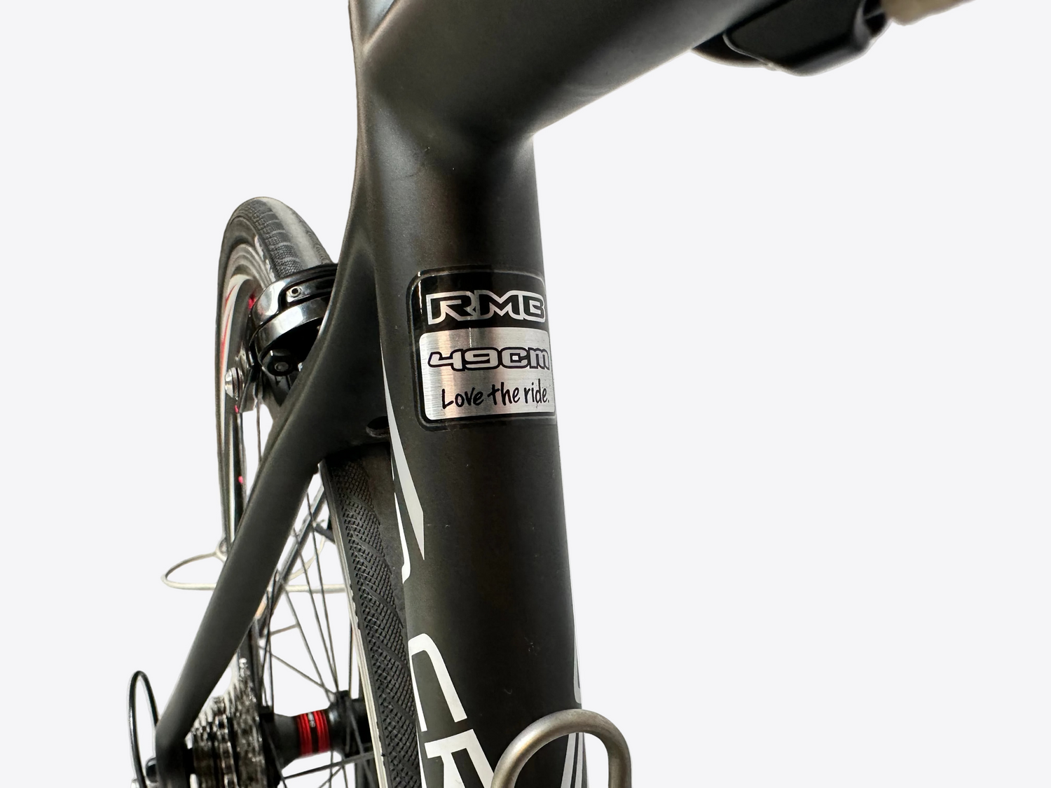Close-up of a bicycle frame with a visible brand logo on a blurred indoor background