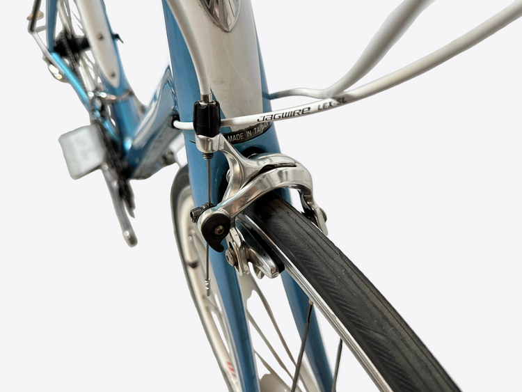 Close-up of a bicycle's front wheel and  fork on a blurred background