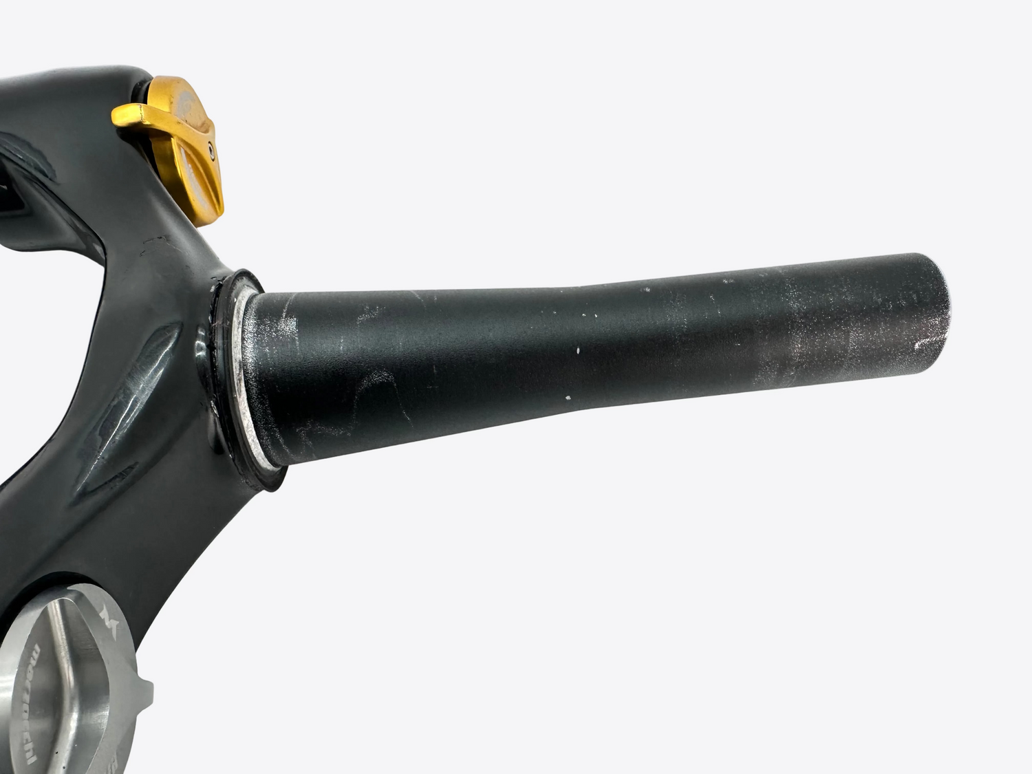 Close-up of a black bicycle handlebar with gold accents on a white background