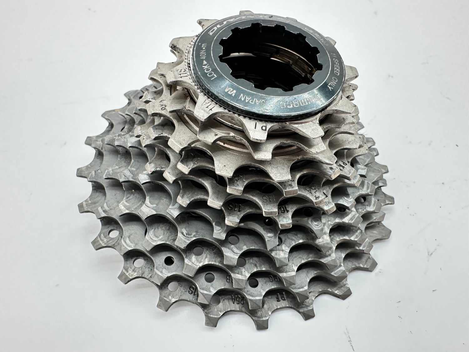 Metallic bicycle gear cassette on a white background