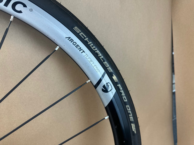 Bicycle wheel with Schwalbe Pro One tire on a cardboard background