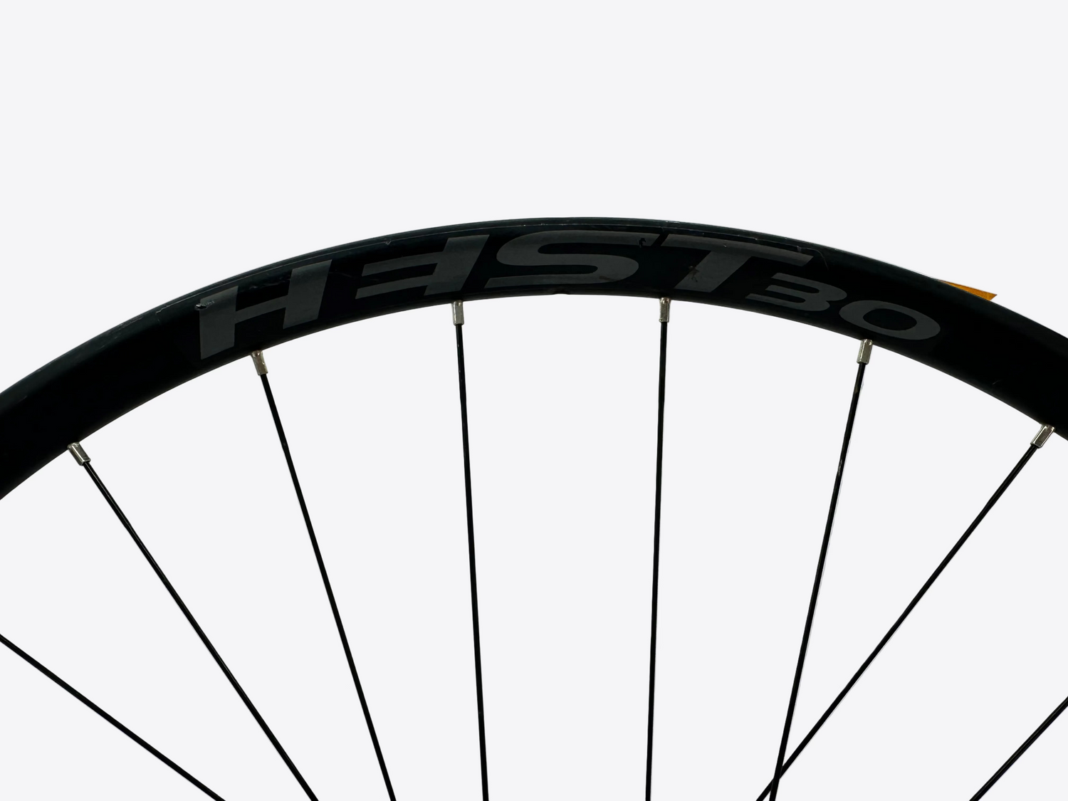 Close-up of a bicycle wheel with HEST 30 branding on a white background