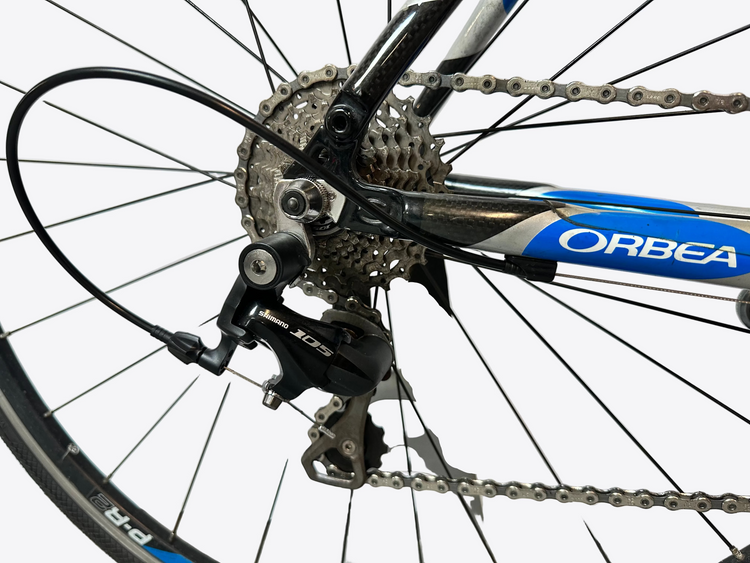 Close-up of a bicycle gear system with 'Orbea' branding on a blurred background