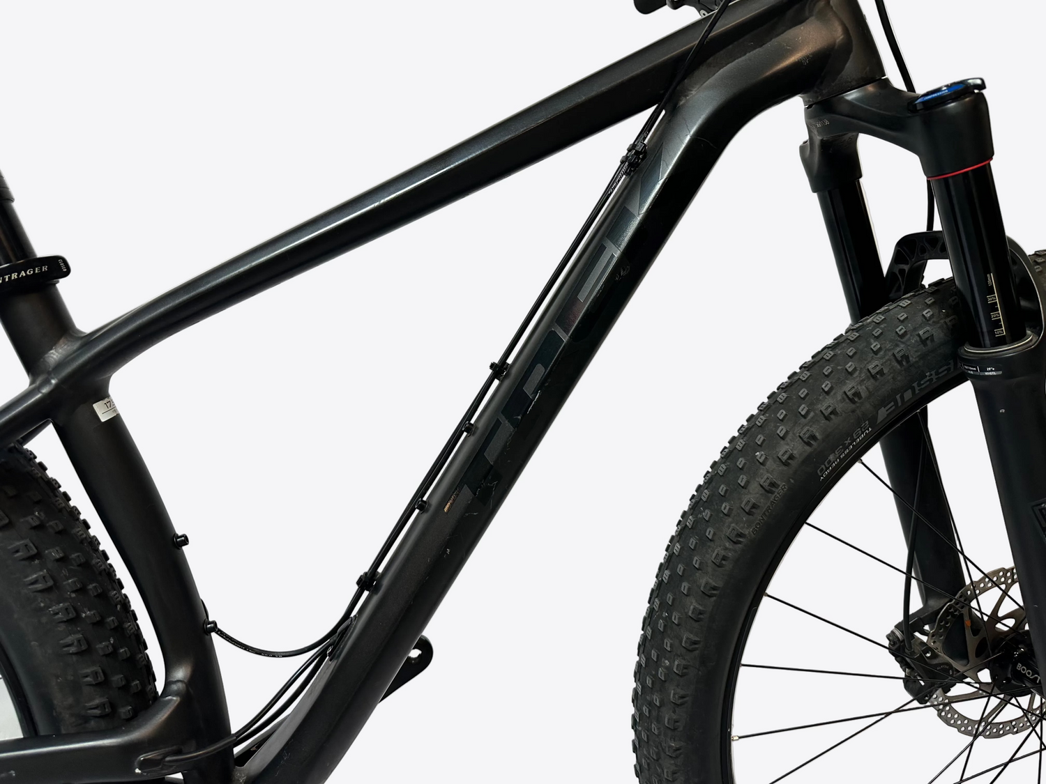 Close-up of a black mountain bike frame and tire on a white background