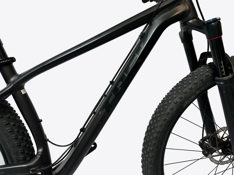 Close-up of a black mountain bike frame and tire on a white background