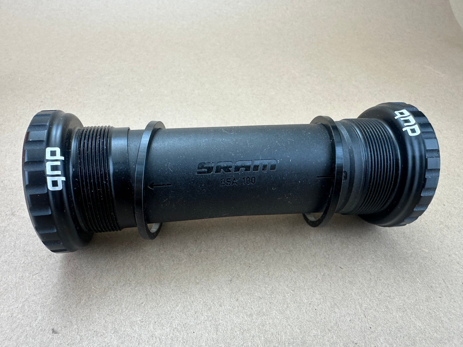 Black sram bicycle bottom bracket on a beige surface