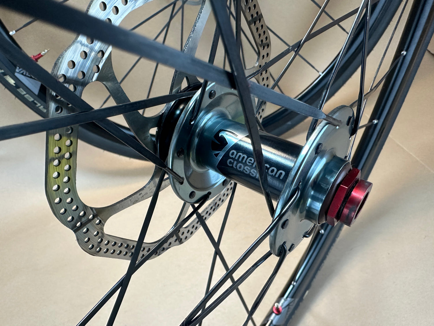 Close-up of a bicycle hub with disc brake rotor on a neutral background