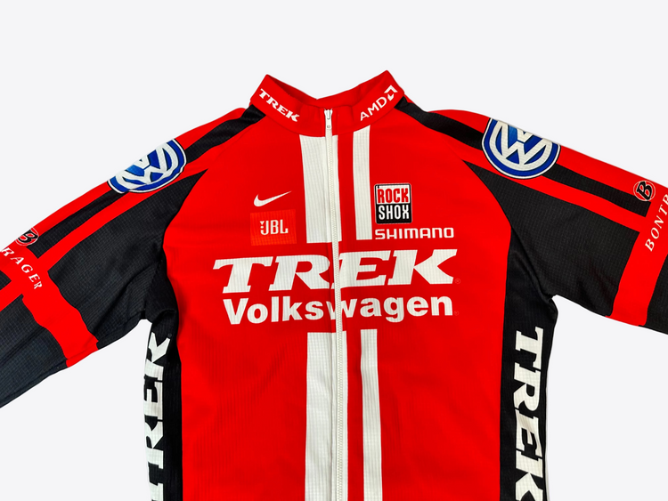 Red and black cycling jersey with various brand logos on a white background