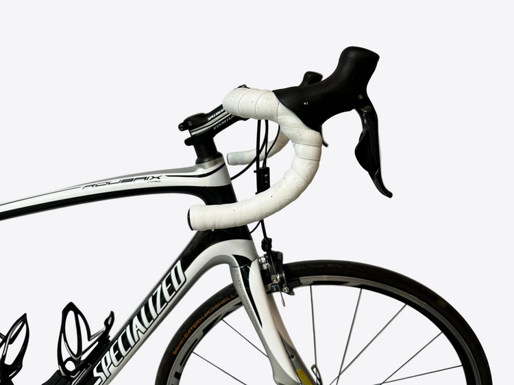 Close-up of a Specialized bicycle with white handlebars and black frame against a plain background