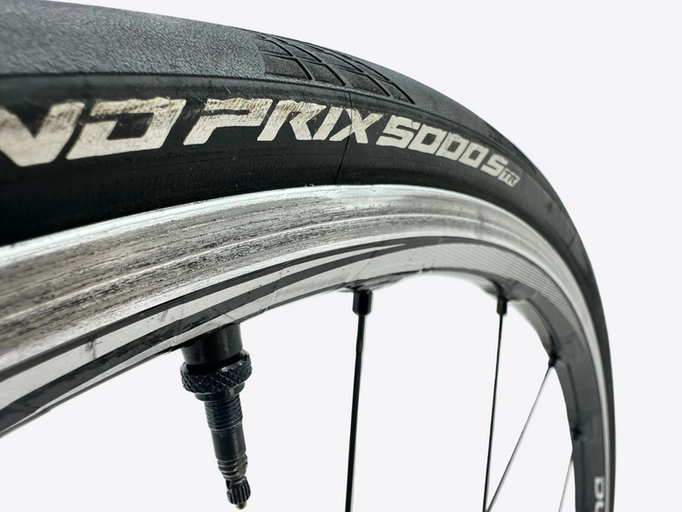 Close-up of a bicycle tire with 'Prix 5000' branding on a white background