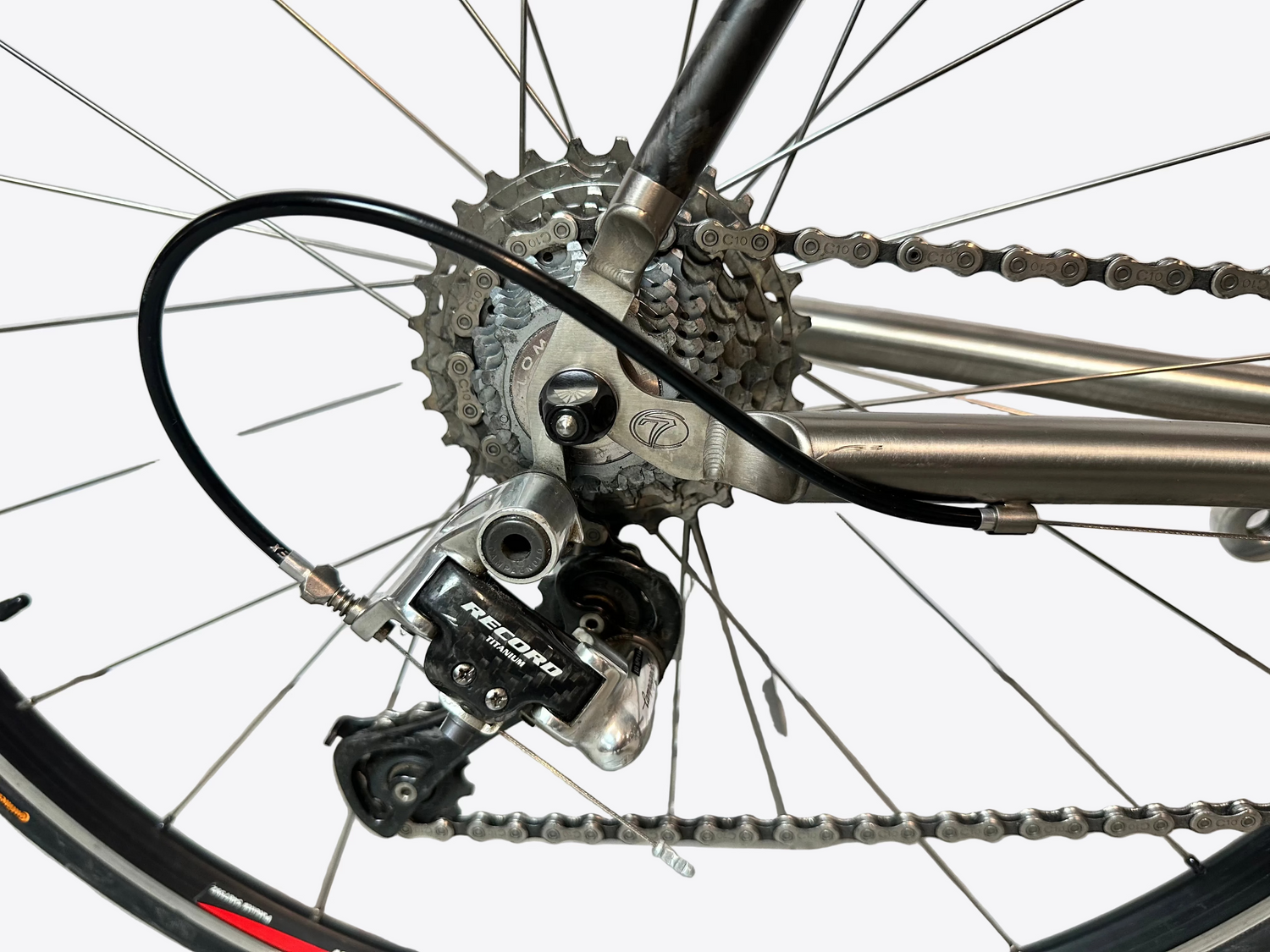 Close-up of a bicycle's gear system on a tiled floor.