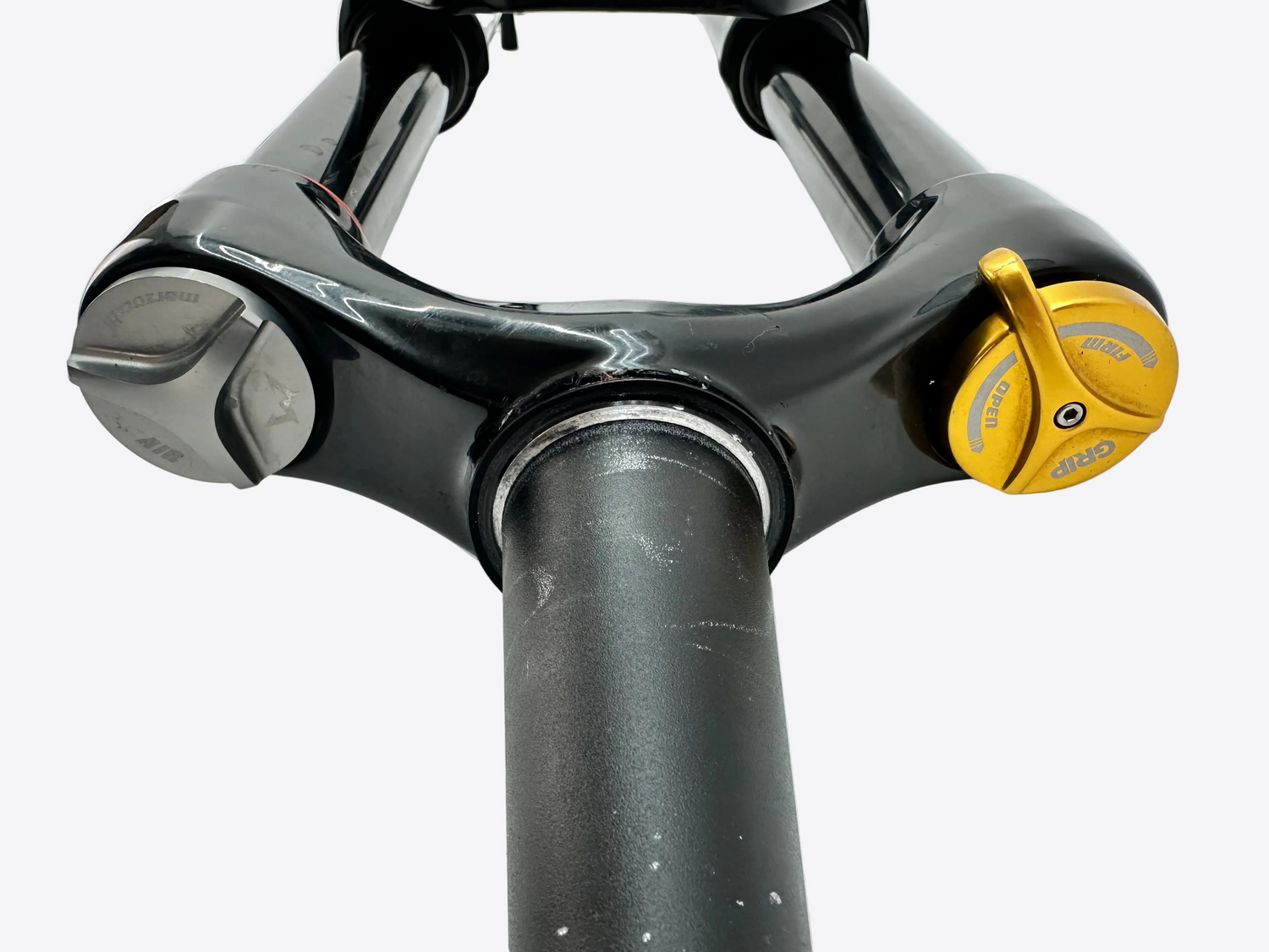 Close-up of a bicycle fork with a yellow lock on a white background