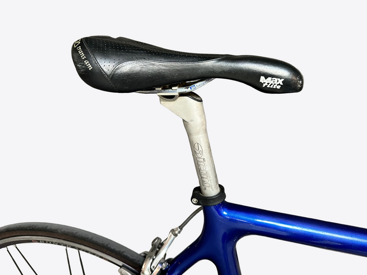 Bicycle seat and frame against a gray tiled wall