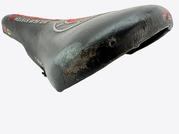 Worn bicycle seat with visible branding on a white background