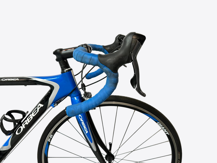 Blue and black Orbea bicycle with handlebars and front wheel on a light gray background