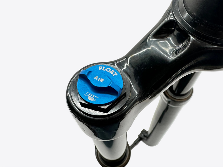 Close-up of a suspension fork with an air valve on a white background