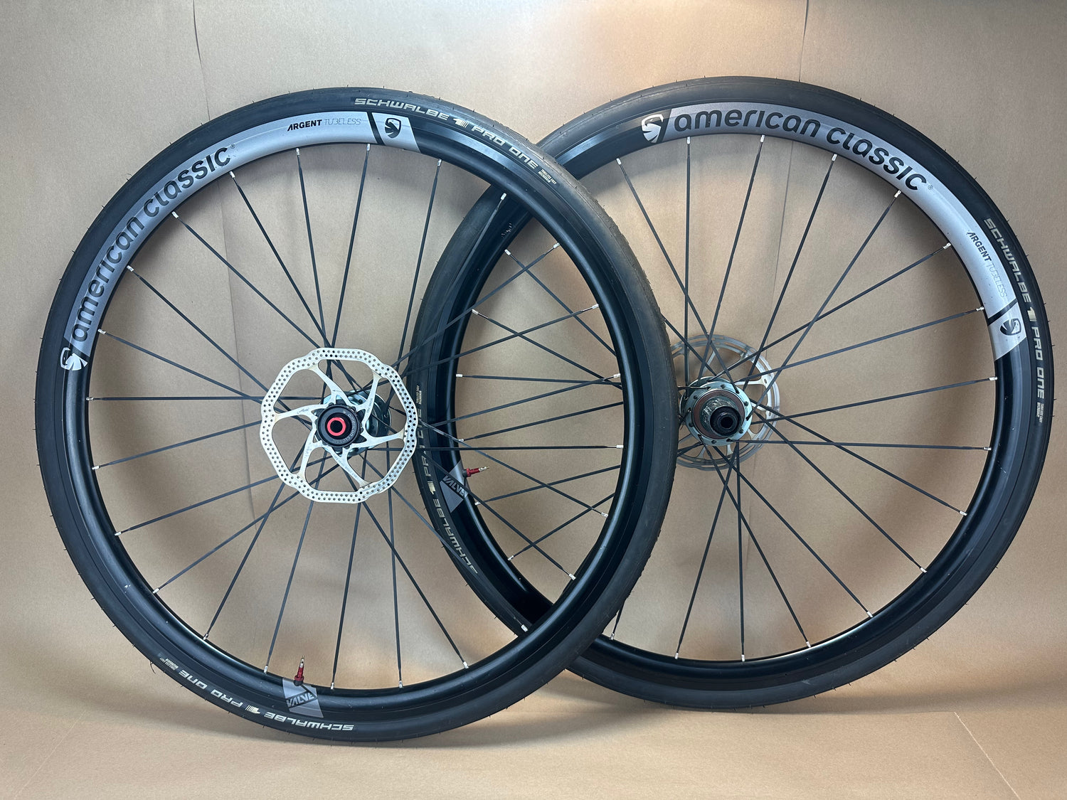 Two bicycle wheels with 'American Classic' branding on a beige background