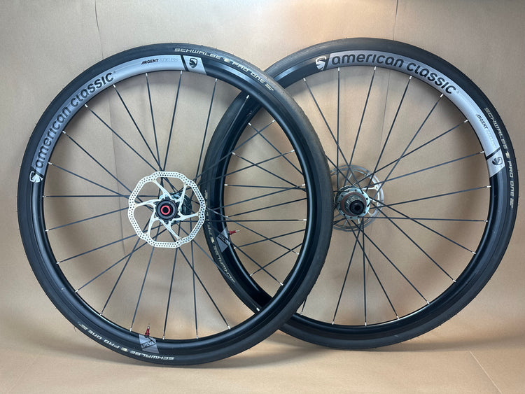 Two bicycle wheels with 'American Classic' branding on a beige background