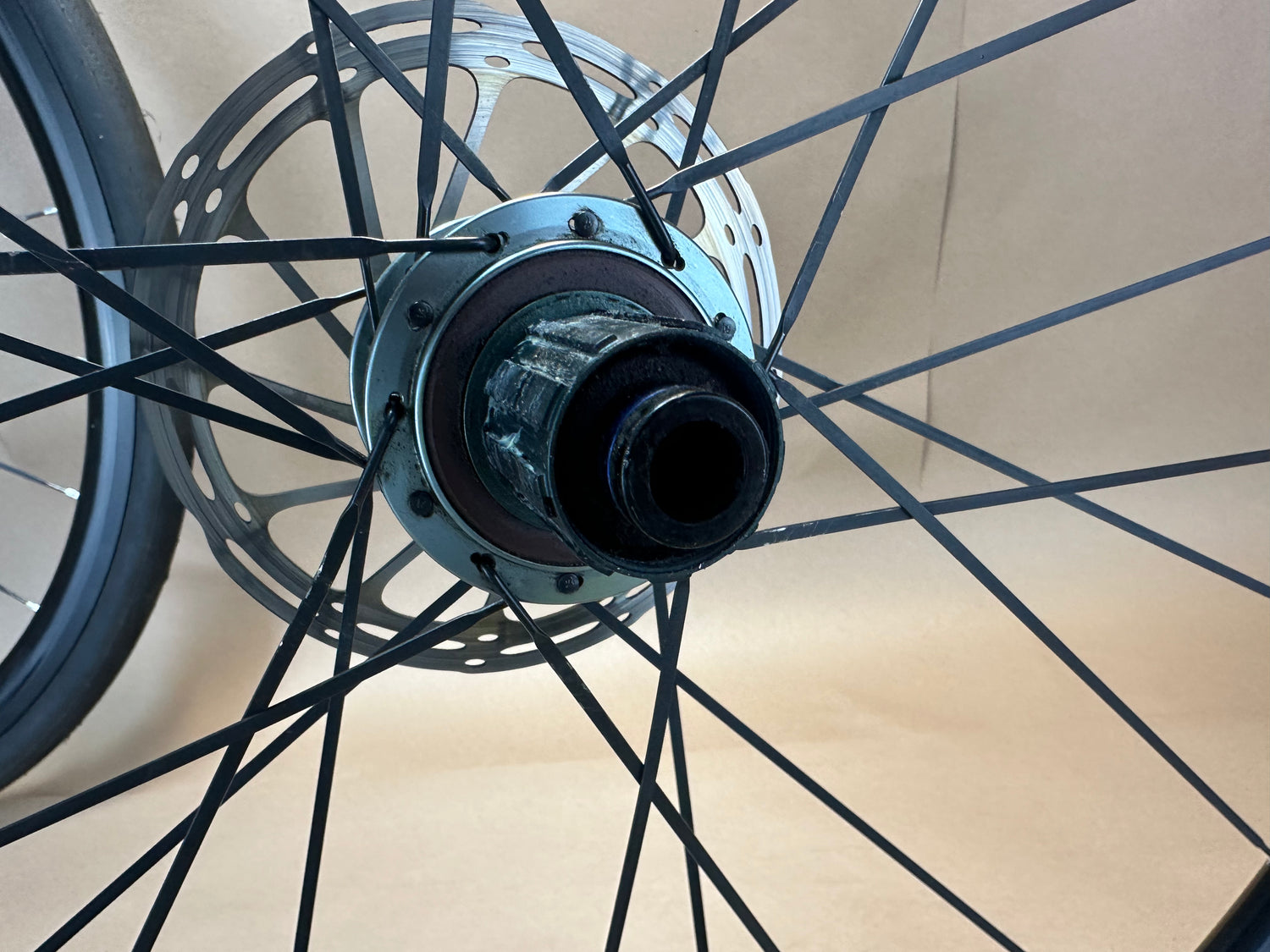 Close-up of a bicycle hub and spokes on a beige background