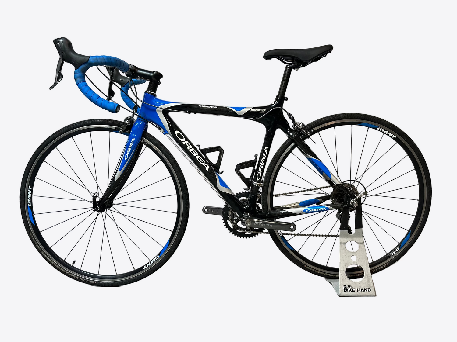 Black and blue bicycle on a stand against a white background